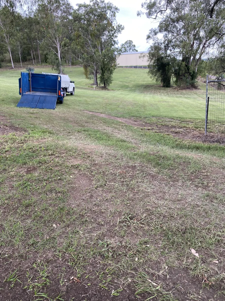Open acreage block mown out to the treeline at Laidley, with the ute and trailer set up on site
